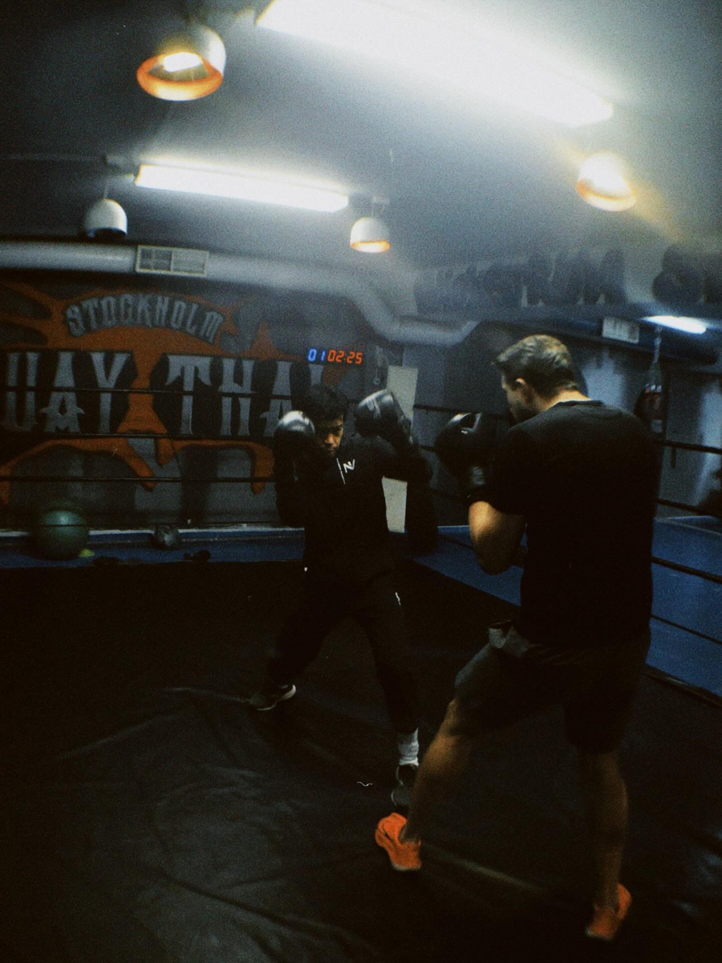 En pojke och man tränar thaiboxning på Stockholm Muay Thai